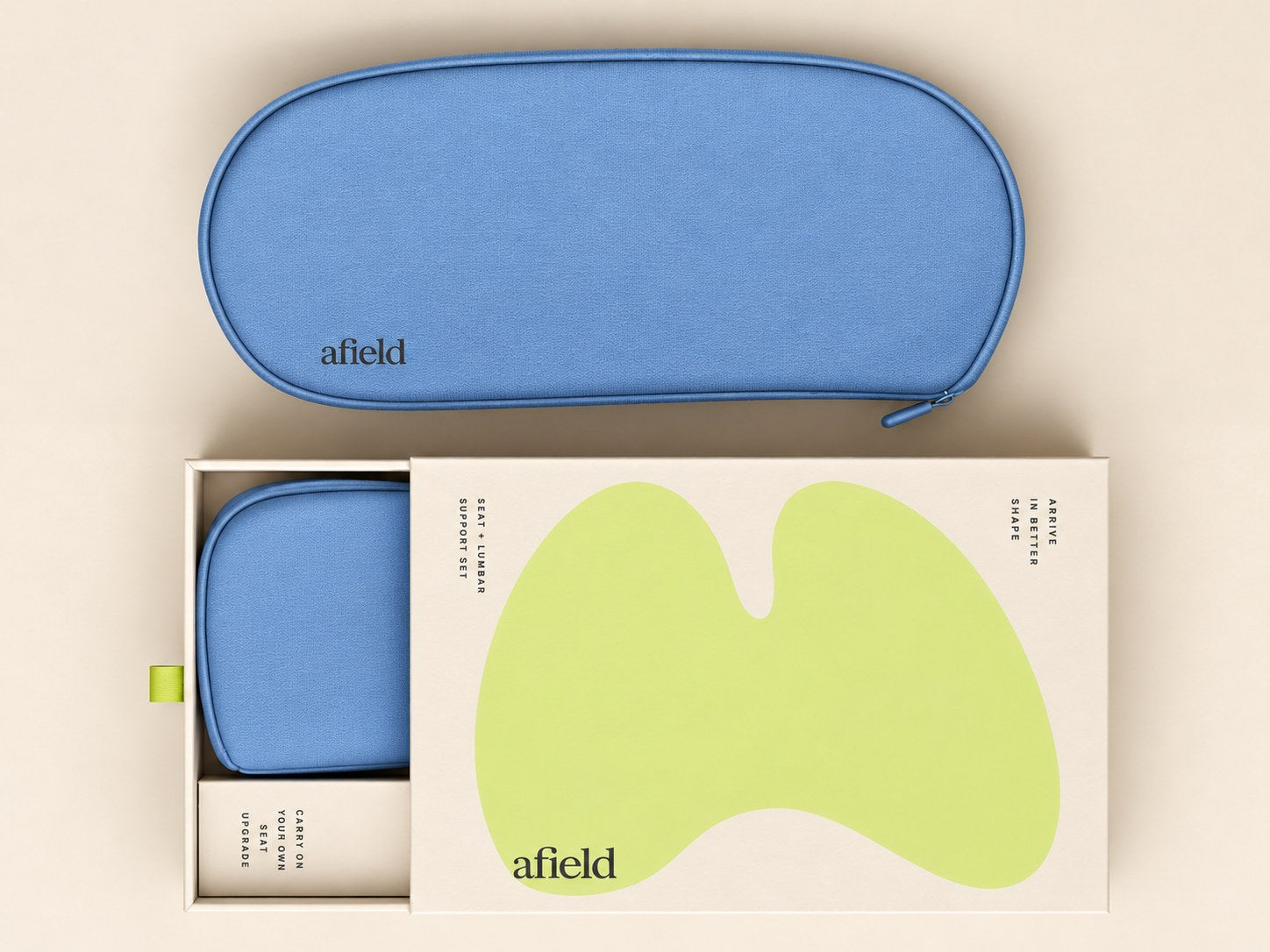 The afield seat and lumbar support set: a blue zippered carry case beside its cream gift box, partly slid open